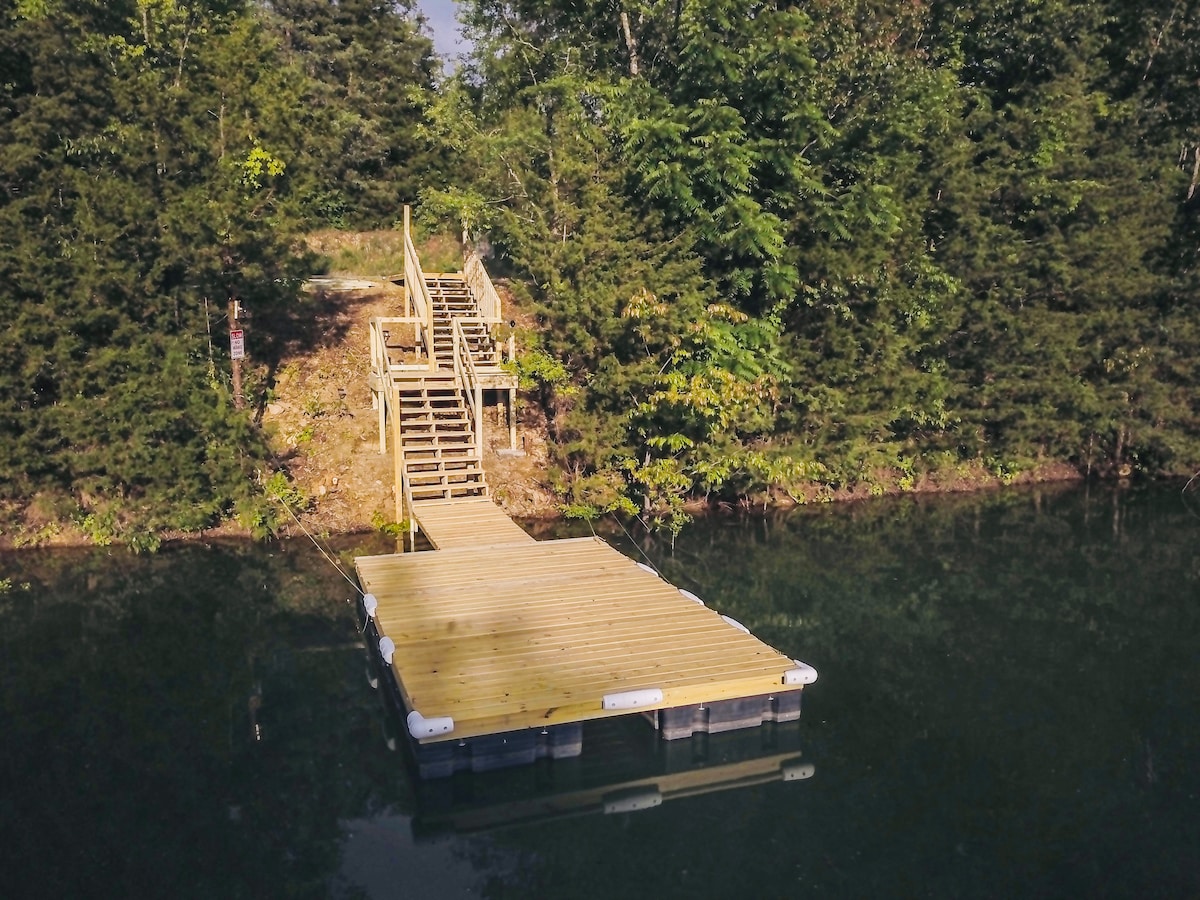 Floating dock connected by stairs to the wooded shoreline